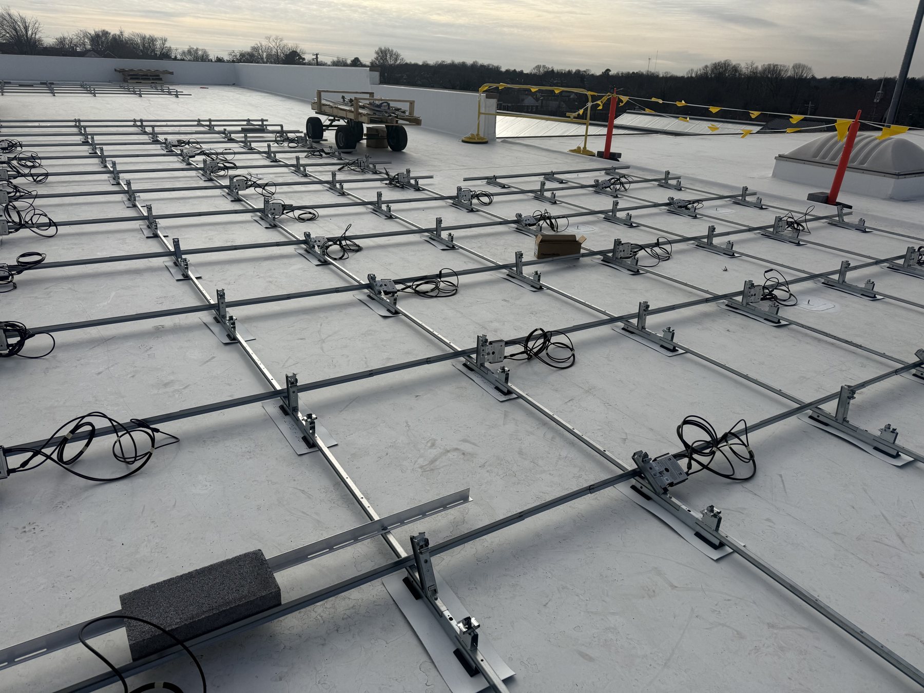 Ballasted racking and pre-wired string wiring up close on the Towson rooftop, January 2026